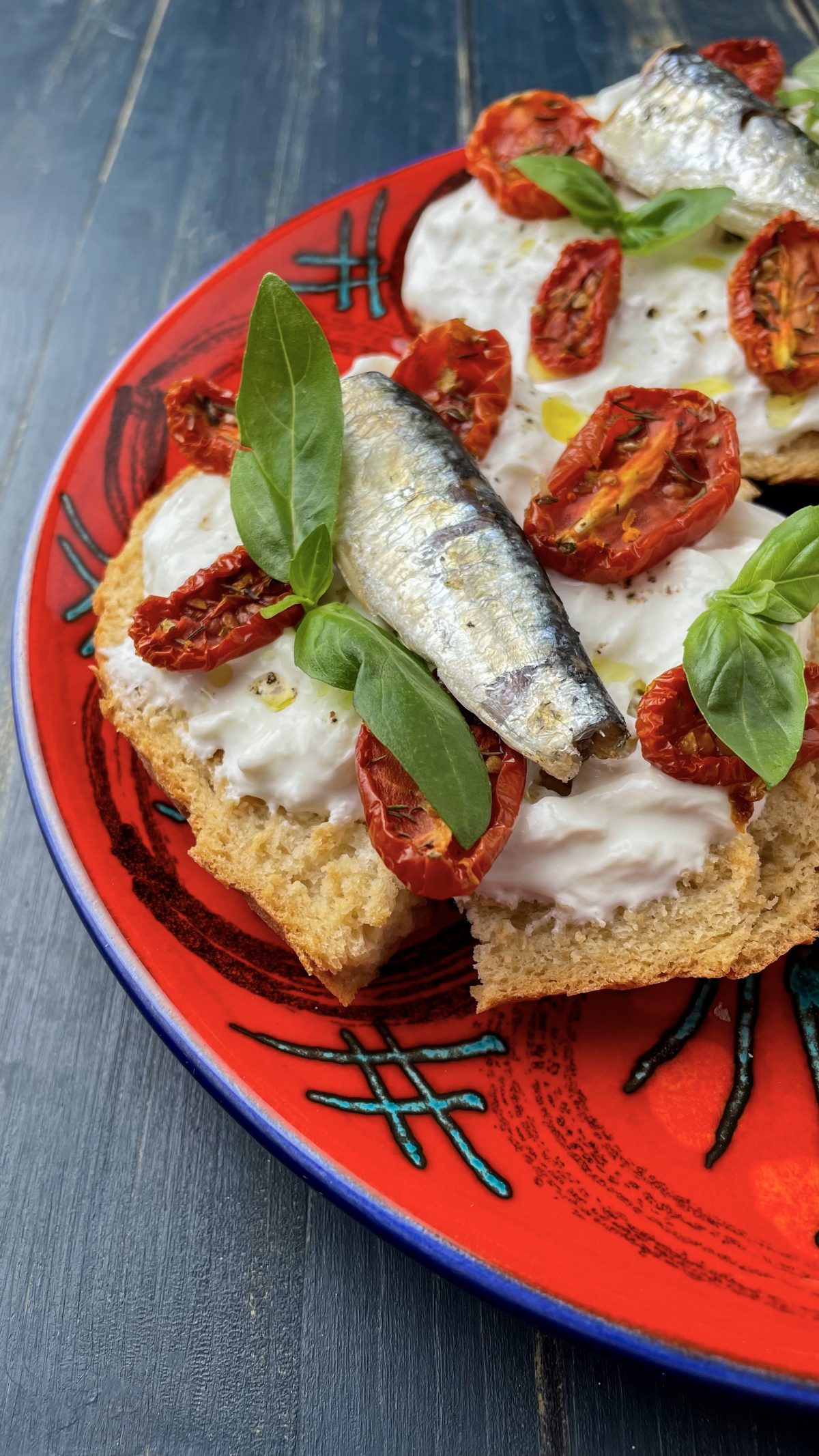 Frisella con stracciatella, pomodorini confit, basilico e sardine